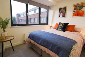 a bedroom with a bed and a large window at Vibrant 2BR King Retreat - Parking, Gym & Wi-Fi! in Bedford