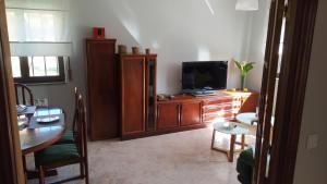 sala de estar con TV y mesa de comedor en Casa la Juncara, en Guarnizo