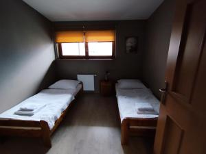 2 letti in una piccola camera con finestra di Apartament Kameralny a Ustroń