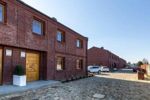 a brick building with a brown door on a street at PATEK Premium Apartments - Airport & MTP in Skórzewo