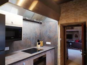 uma cozinha com um lavatório e um fogão forno superior em Appartement Prestige Résidentiel 3 chambres 3 salles de bain au Manoir de Mathan à Crépon 5 mn d'Arromanches et 10 mn de Bayeux em Crépon