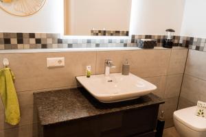 a bathroom with a sink and a toilet at FeWo-Seefunkeln in Diensdorf am Scharmützelsee in Diensdorf-Radlow +16 photos