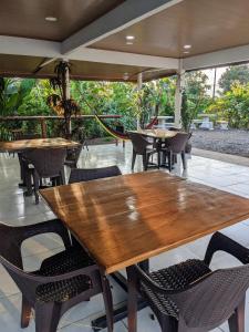 un patio esterno con tavoli e sedie in legno di Sunrise a Bahía Drake