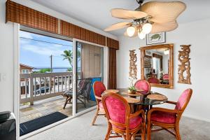 comedor con mesa y sillas y balcón en Kahaluu Reef 203, en Kailua-Kona