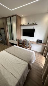 1 dormitorio con 1 cama, TV y sillas en Moov 1417 Studio Mooca, en São Paulo