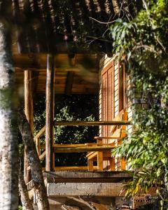 una finestra aperta di una casa in legno con alberi di Pousada Aceguá a Praia Grande