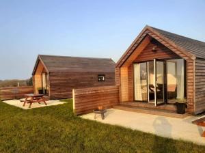a log cabin with a picnic table and a table at Islandcorr Farm Luxury Glamping Lodges and Self Catering Cottage, Giant's Causeway in Bushmills