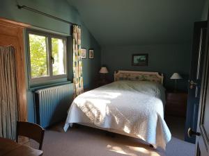 Schlafzimmer mit einem Bett und einem Fenster in der Unterkunft Le petit Ermitage in Méré