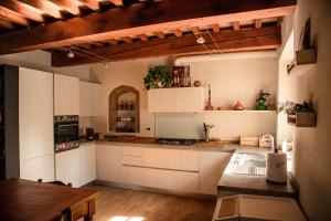 a kitchen with white cabinets and a wooden table at Social Garden - Private Room in Calci