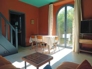 ein Wohnzimmer mit einem Tisch und einem Fenster in der Unterkunft Le petit Ermitage in Méré