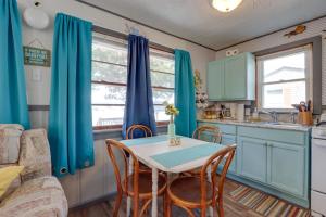 a kitchen with blue cabinets and a table and chairs at Cozy Camdenton Cottage with Deck and Boat Dock Access! in Camdenton