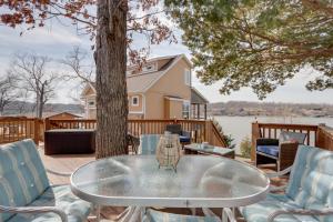 a glass table and chairs on a deck with a tree at Cozy Camdenton Cottage with Deck and Boat Dock Access! in Camdenton