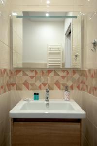La salle de bains est pourvue d'un lavabo et d'un miroir. dans l'établissement Rocciola Home, à Salerne