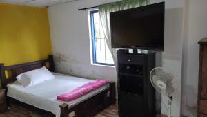 a bedroom with a bed with a television and a fan at La posada de Andrea in Pueblo Tapao