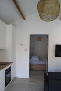 een kamer met een keuken en een kamer met een bed bij Maisonnette 2 pièces 100m de la plage de la Clère in Le Grand Vieil
