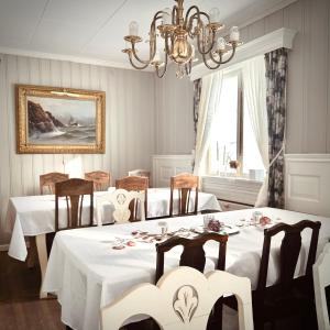 a dining room with two tables and a chandelier at VILLA HASSELBAKKEN in Eidsvoll
