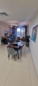 a living room with a table and chairs and a couch at JTower Royal Suites - Alefimmoed in Jerusalem