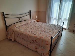ein Schlafzimmer mit einem Bett mit einer orangefarbenen Bettdecke in der Unterkunft Casa vacanze Tommasone in Custonaci