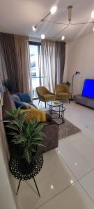 a living room with a couch and a tv at JTower Royal Suites - Alefimmoed in Jerusalem