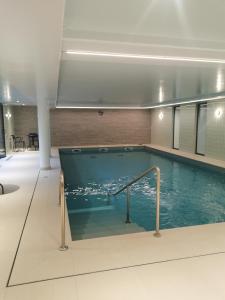 a large swimming pool in a building with a pool at Domitys Le Domaine d'Agate in Soissons