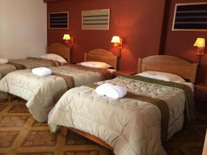 a group of four beds in a room at El Jacal Classic in Huaraz