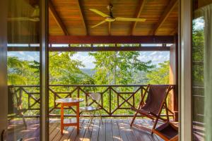 a screened in porch with chairs and a ceiling fan at Punta Studio at Framadani Estate in San Ignacio