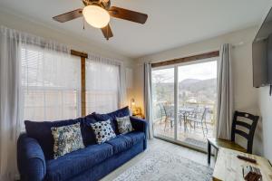ein Wohnzimmer mit einem blauen Sofa und einem großen Fenster in der Unterkunft Hilltop Hideaway with Scenic Views and Hot Tub! in West Jefferson