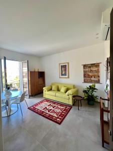 ein Wohnzimmer mit einem gelben Sofa und einem Tisch in der Unterkunft Case Orlando_a city center Sicilian treat in Palermo
