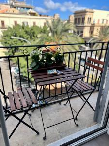 einen Holztisch und zwei Stühle auf dem Balkon in der Unterkunft Case Orlando_a city center Sicilian treat in Palermo