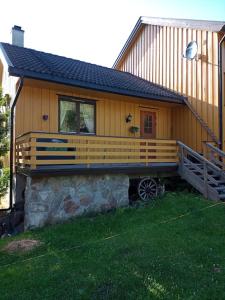 Una gran casa de madera con un gran porche. en Leilighet på gård en Sauland