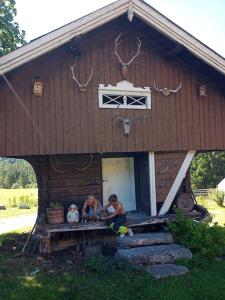 dos personas sentadas en el porche de una casa en Leilighet på gård en Sauland