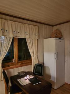 a kitchen with a table and a white refrigerator at Leilighet på gård in Sauland