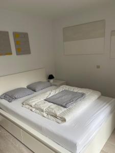 ein weißes Bett mit zwei Kissen darüber in der Unterkunft Blankeduyn Koksijde in Koksijde