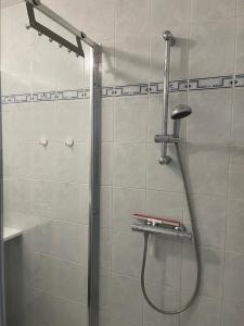 een douche met een douchekop in de badkamer bij Blankeduyn Koksijde in Koksijde