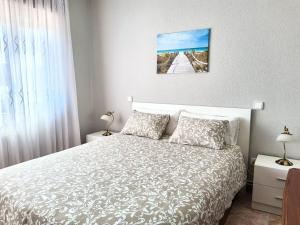a bedroom with a white bed and a window at Casa la Juncara in Guarnizo
