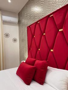 einem roten gepolsterten Kopfteil eines Bettes mit roten Kissen in der Unterkunft Easy Boarding in Neapel