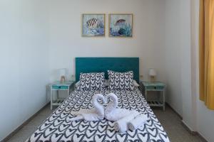a bedroom with a bed with two stuffed animals on it at Apartamentos con vistas al mar en El Remo in Los Llanos de Aridane