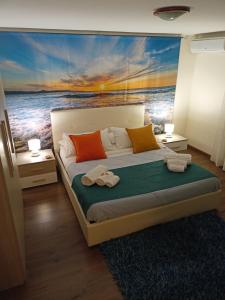 una camera da letto con un dipinto dell'oceano di La Petite Maison ad Aci Castello