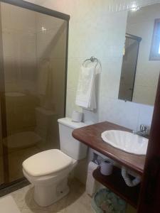 a bathroom with a toilet and a sink at Hotel Fazenda VCP in Silva Jardim