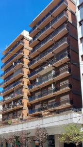 Un edificio de apartamentos con balcones a los lados. en Manilo House, en Mar del Plata
