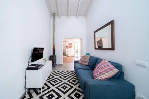 un soggiorno con divano blu e specchio di Peaceful, spacious & stylish, a real home! a Budens