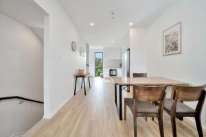 a dining room and living room with a table and chairs at New modern townhouse in the heart of Takapuna in Auckland