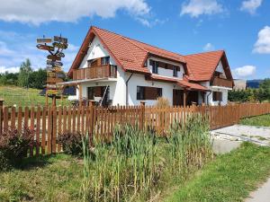 a house with a wooden fence in front of it at Dom Podróżnika in Maniowy