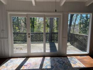 une porte coulissante en verre ouverte avec une terrasse en bois dans l'établissement Recently renovated Haven in Brookhaven., à Atlanta