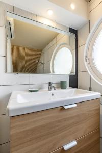 a bathroom with a white sink and a mirror at L'annexe Landaise in Saint-Martin-de-Seignanx