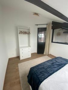 ein Schlafzimmer mit einem Bett, einer Kommode und einem Fenster in der Unterkunft La cabane d’Emile - Parc Ste Marie - Nancy Thermal in Nancy