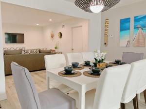 comedor con mesa blanca y sillas blancas en @ Marbellalane - Neat Modern Home in South SF, en South San Francisco