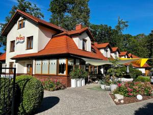 a building with an orange roof and a restaurant at Apartamenty PRIMA in Rewal