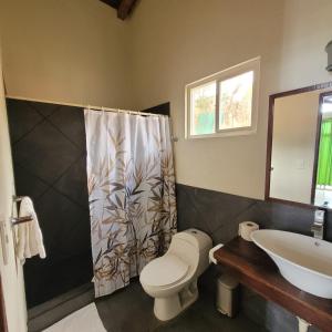 uma casa de banho com um WC e um lavatório em Kayu Surf Resort em La Libertad