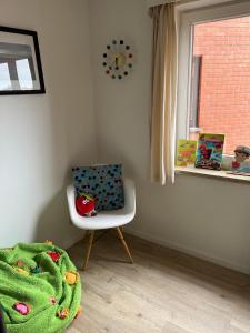 Habitación infantil con silla y ventana en La Bohème Koksijde, en Koksijde